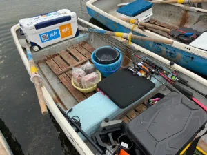 [手漕ぎボートに積み込んだ竿やクーラーボックスなどの釣り道具]